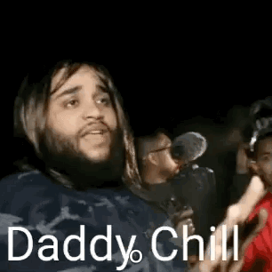 A man in a dark crowd shouts “Daddy Chill.”