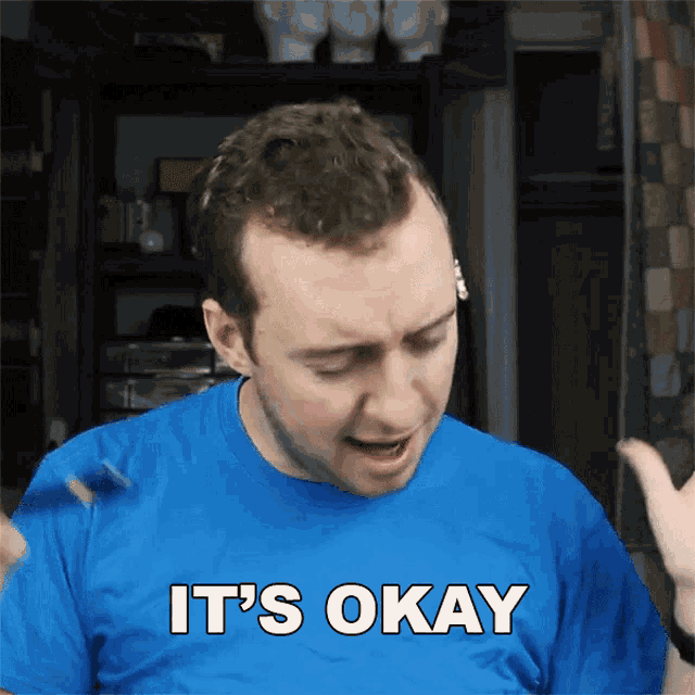 a man wearing a blue shirt that says it 's okay
