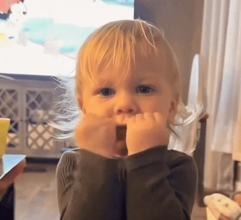 a little boy with blonde hair is making a surprised face