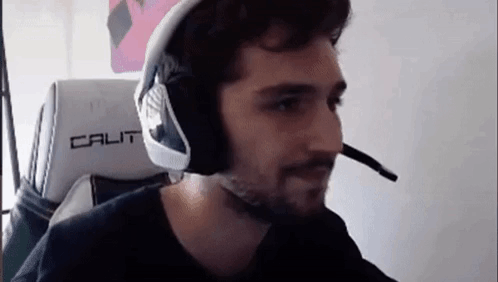 a man is wearing headphones and a microphone while sitting in a gaming chair .