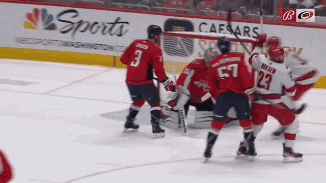 a hockey game is being played in front of an ad for caesars