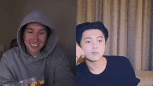 a man wearing a hoodie is smiling next to another man wearing a black shirt