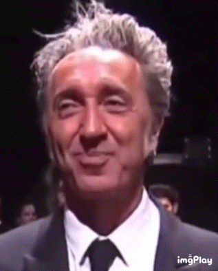 a close up of a man in a suit and tie smiling .