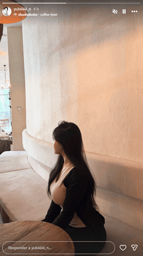 a woman is sitting at a table in a room with the words responder a yubiiii n on the bottom right