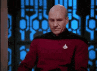Captain Picard performs a facepalm in a Star Trek uniform.