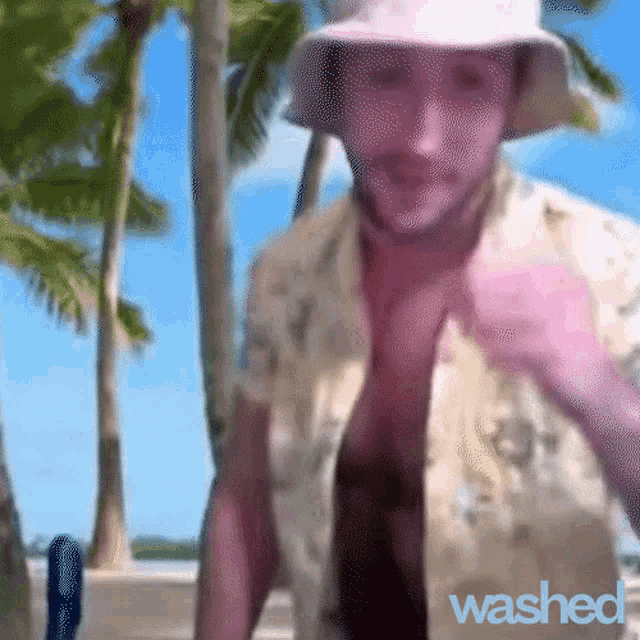 a man wearing a hat and a shirt that says " washed "