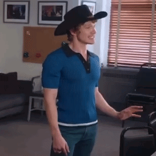 a man wearing a cowboy hat is standing in a room .