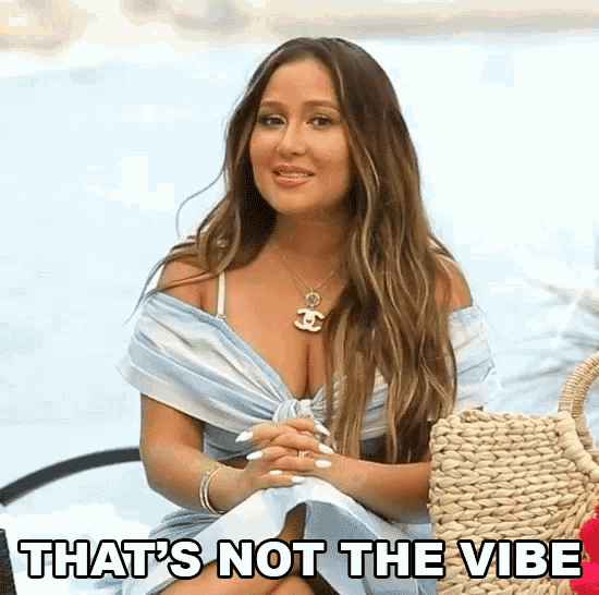 a woman is sitting on a beach with the words that 's not the vibe written on the bottom