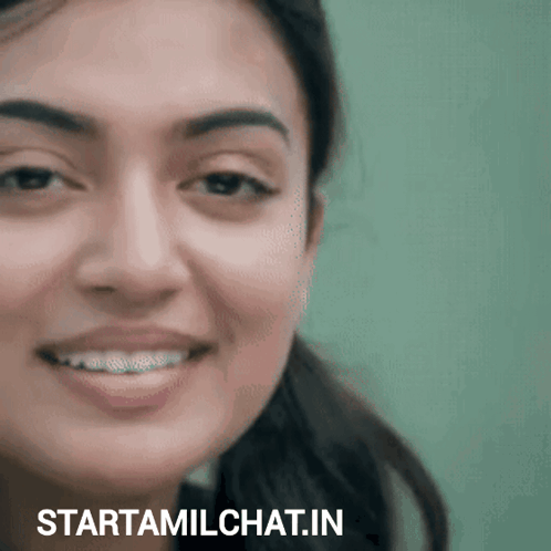 A woman smiles gently in a close-up video shot.