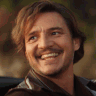 Pedro Pascal smiles broadly in a warm close-up shot.