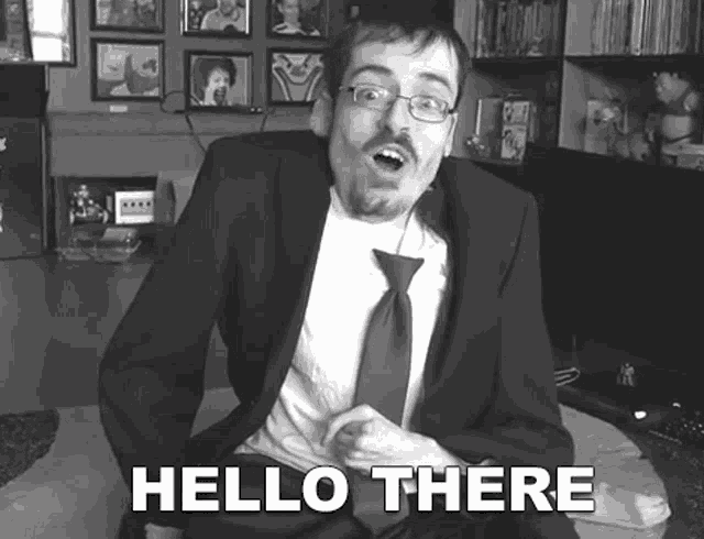 a black and white photo of a man in a suit and tie says hello there