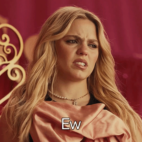A blonde woman in a gold-toned costume looks disgusted beneath “Ew.”
