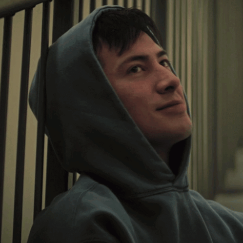 a man with his eyes closed wearing a hooded sweatshirt