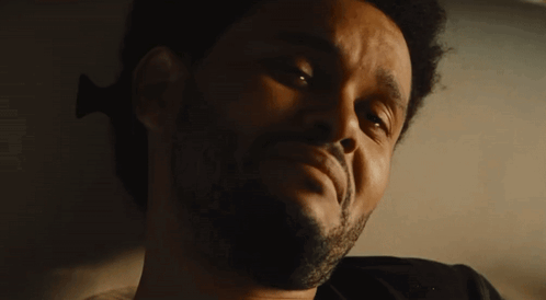 a close up of a man 's face with a beard and a black shirt .