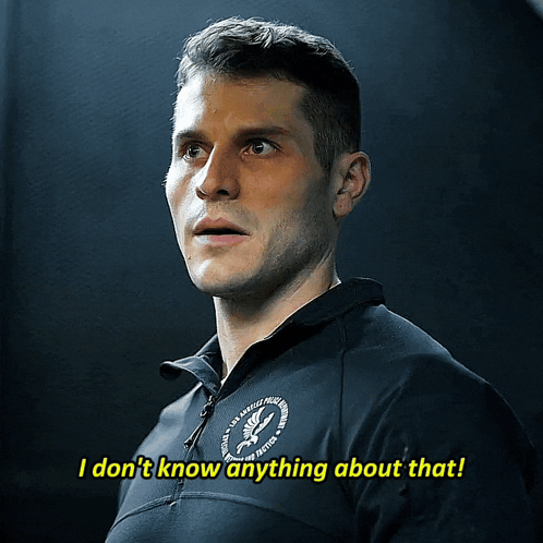 a man wearing a black shirt that says i don t know anything about that