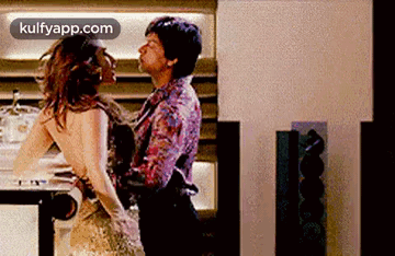 a man is holding a woman in his arms while dancing in a room .