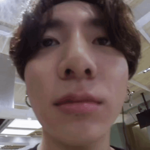 An extreme low-angle close-up shows a man looking into the camera indoors.