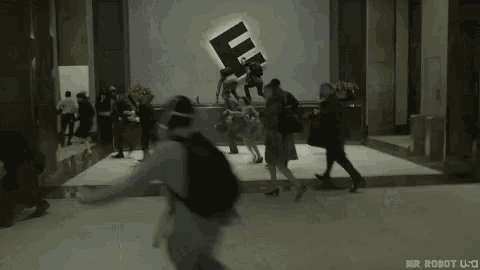 a group of people are walking down a hallway .