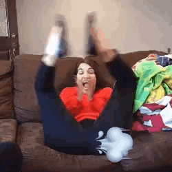 a woman is sitting on a couch with her legs in the air