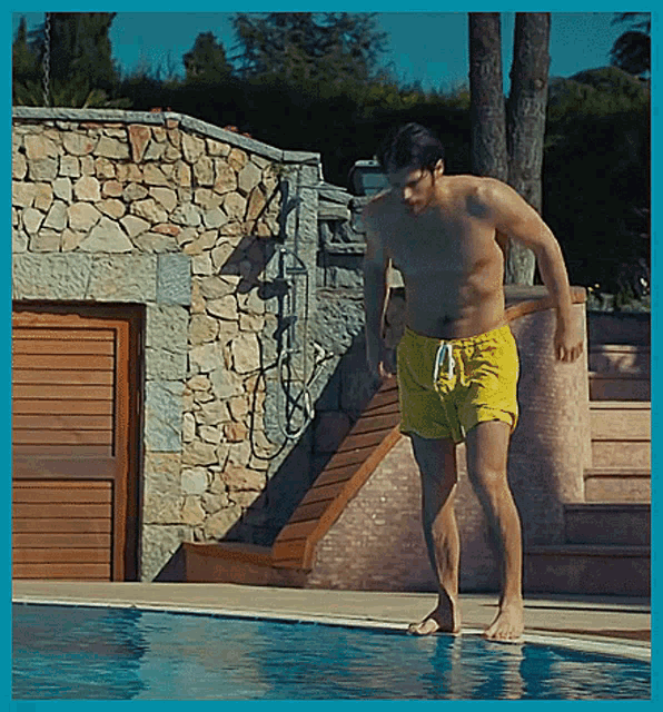 a shirtless man is jumping into a swimming pool