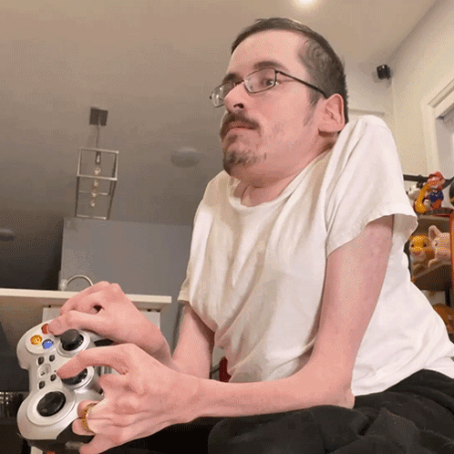 a man with a beard and glasses is playing a video game