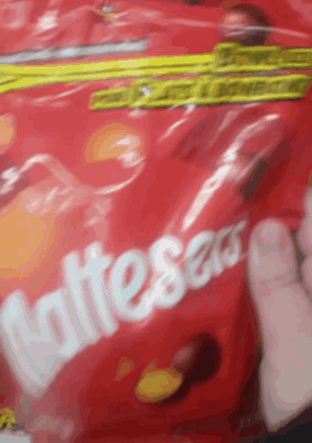 someone is holding a bag of skittles candy