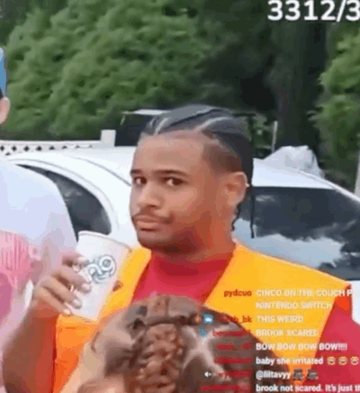 a man in a red shirt and orange vest is holding a cup of coffee .