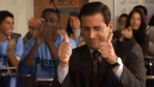A group of office workers enthusiastically gives thumbs up.