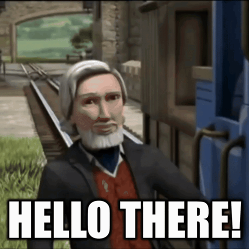 a man with a beard is standing next to a train track and says hello there