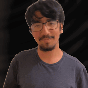 a man with glasses and a beard is wearing a grey shirt