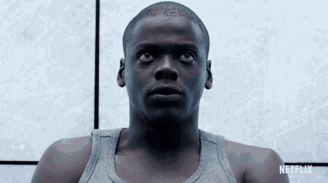 a man in a grey tank top with netflix on the bottom