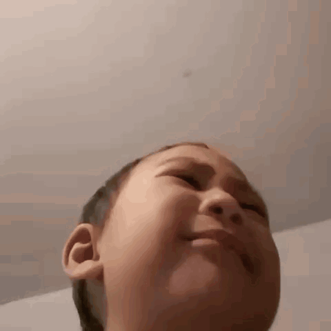 A young child looks up toward the camera with a tearful, overwhelmed expression.