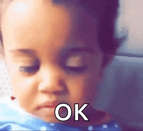 A baby looks downward with a weary eye-roll-like expression and “OK” text.