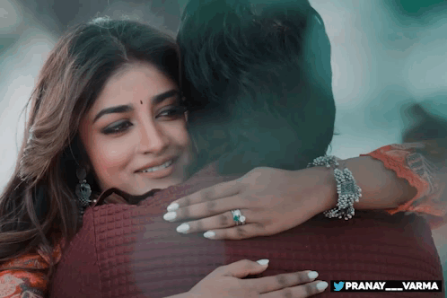 a woman is hugging a man with the name pranay_varma on the bottom right