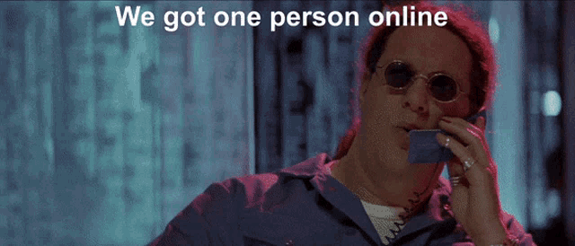 a man talking on a cell phone with the words we got one person online behind him