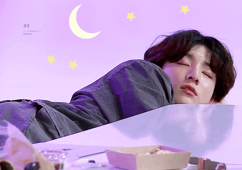 A man lies asleep under a purple moon-and-stars graphic.
