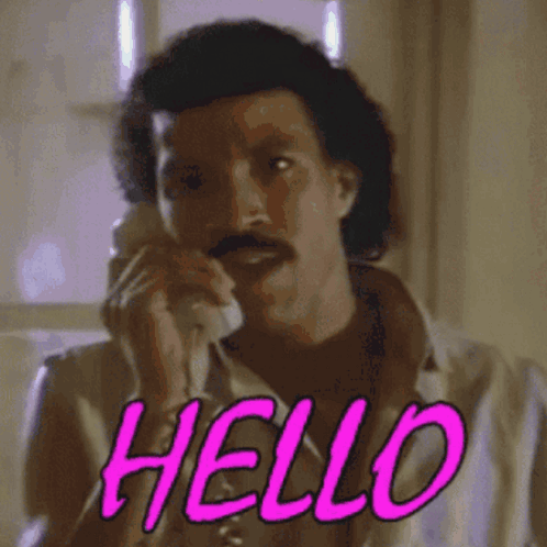 A man holds a phone with bright pink “HELLO” lettering.