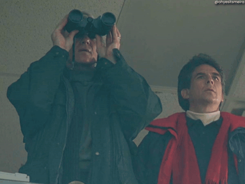 a man holding a camera with the words this is embarrassing behind him