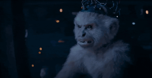 a person is typing on a keyboard with a monkey 's hands visible