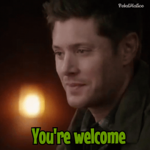 Dean Winchester looks to the side in a dimly lit scene with a candle behind him.