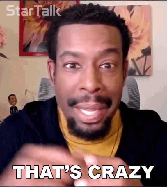 a man with a beard says that 's crazy while smiling
