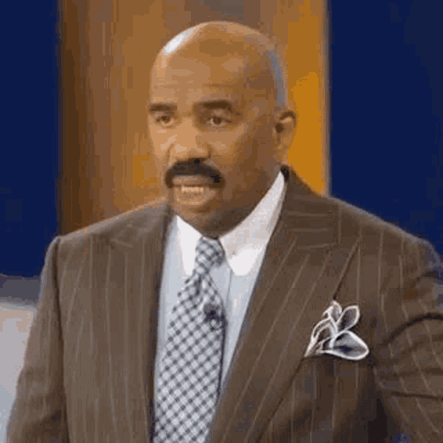 Steve Harvey looks forward with a stunned, questioning expression.