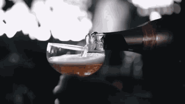 a person is pouring beer into a glass in a bar .