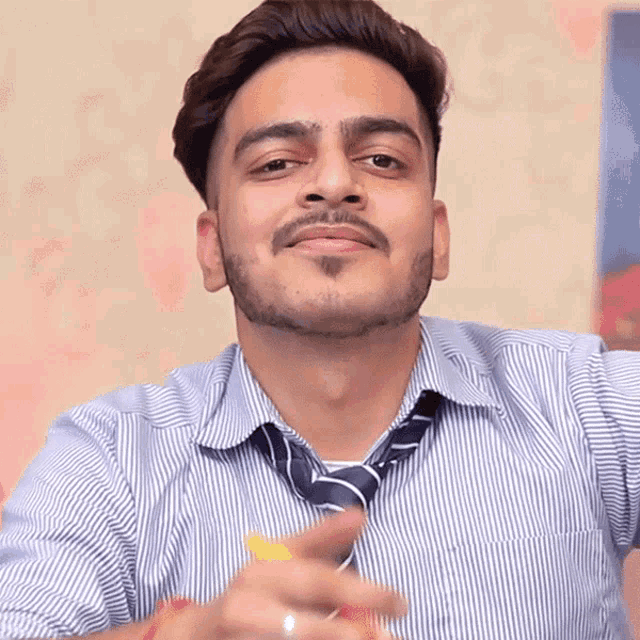 a man wearing a striped shirt and tie is making a funny face