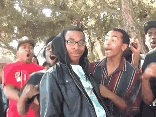 A crowd erupts behind a man after an apparent verbal takedown.