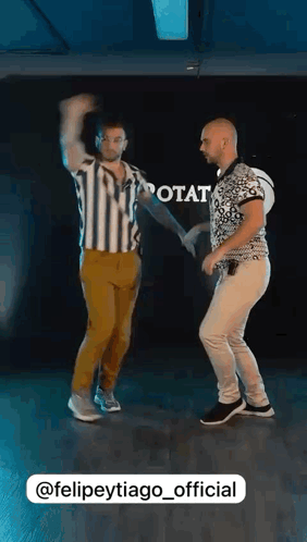 two men are dancing together in a dance studio with the words @felipeytiago_official at the bottom