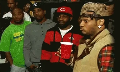 A group of men stare skeptically, reacting as if a take missed the mark.