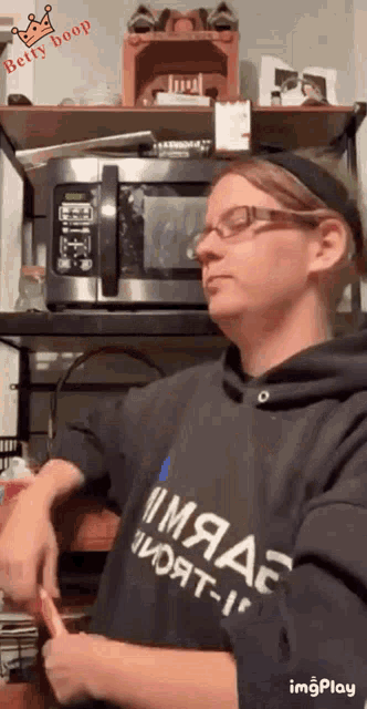 a woman wearing a black shirt that says betty poop on it