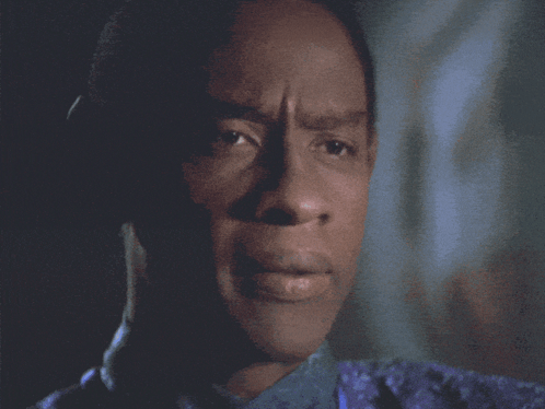 Tuvok gives a solemn look in a dark Star Trek scene.