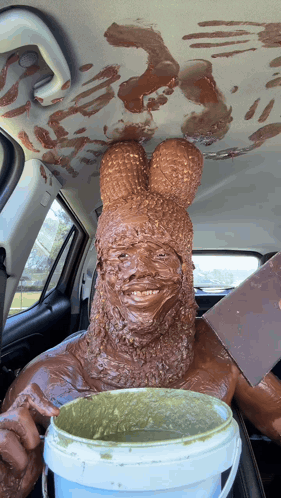 a man is covered in chocolate and is holding a bucket of chocolate